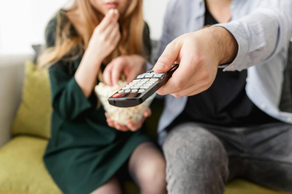 Un telecomando nella mano di un uomo che cambia canale