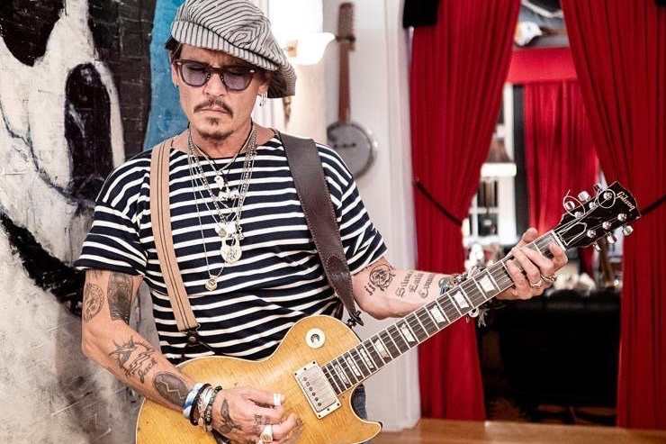 Johnny Depp mentre posa con la sua chitarra