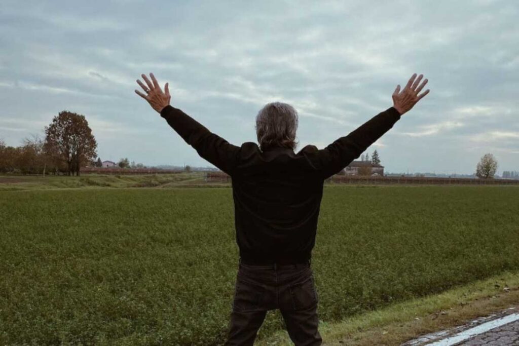 Ligabue di spalle con le braccia alazate a Correggio